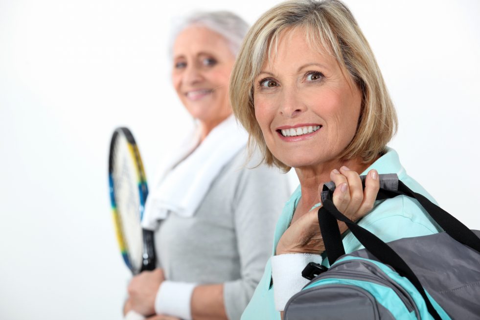 Two mature women playing tennis